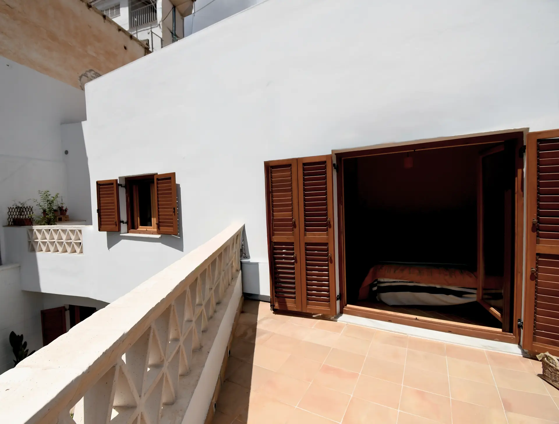 Terraza encalada con contraventanas de madera en la casa cueva de la Bola de Oro (Granada)